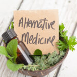 plant with a cardboard piece that reads alternative medicine